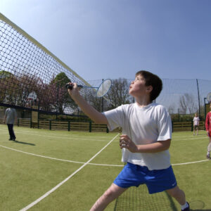 Un enfant jouant au badminton sur un city stade